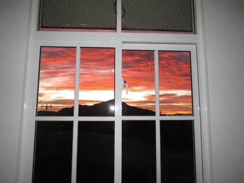 a window with a view of a sunset at Tranquil Villa in Nuwara Eliya