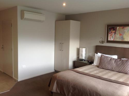 a bedroom with a bed and a white closet at The St James Premium Accommodation in Hanmer Springs