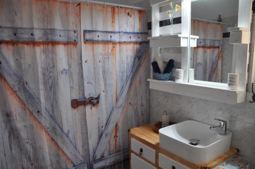 ein Badezimmer mit einem Waschbecken und einer Holzwand in der Unterkunft Your Home in Athen