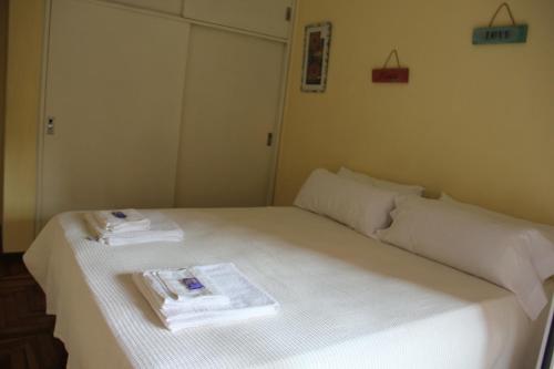 Una cama blanca con dos toallas encima. en Malanca 1 en Córdoba