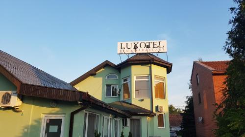 a building with a sign on top of it at Guest House Luxotel in Zrenjanin