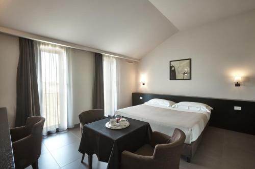 a hotel room with a bed and a table with chairs at Casalgrande Hotel in Salvaterra