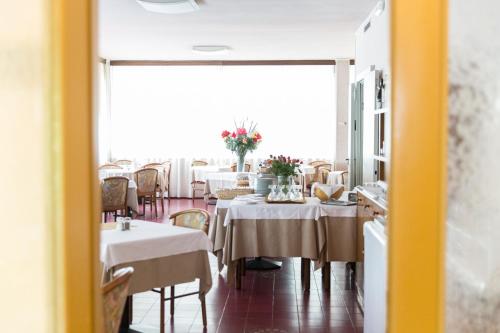 a dining room with tables with white tablecloths at Hotel Gloria in Salsomaggiore Terme