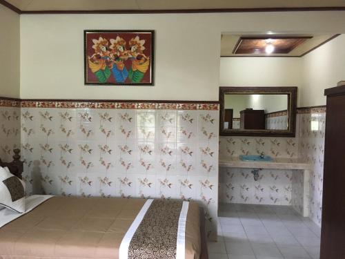 a bedroom with a bed and a mirror at Eka's Homestay in Ubud
