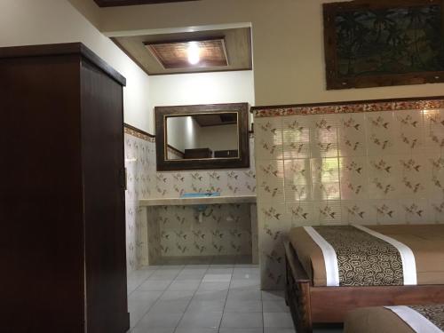 una camera con due letti e uno specchio di Eka's Homestay ad Ubud