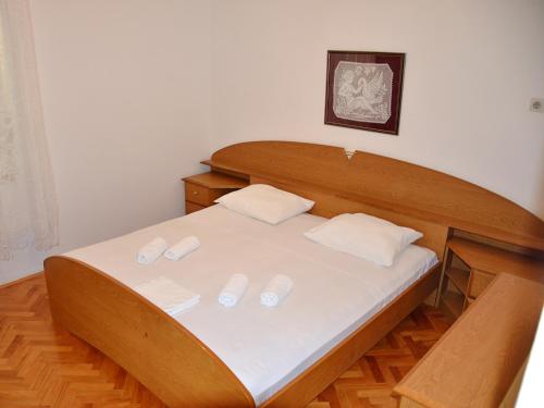 a bed with white sheets and two pillows on it at Apartment Summer Paradise in Novalja