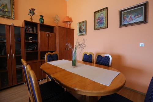 a dining room with a wooden table and chairs at Apartment and rooms Roko in Zaglav