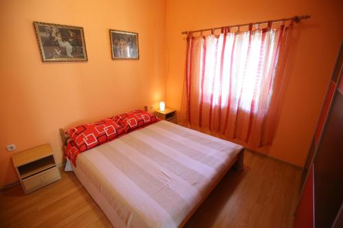 a bedroom with a large bed and a window at Apartment and rooms Roko in Zaglav
