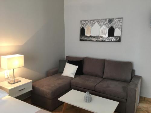 a living room with a couch and a table at Teatro Deluxe Rooms in Kato Rodini