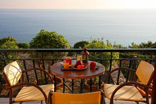 a table with a bowl of fruit on a balcony at Villa Contessa in Vasilikos