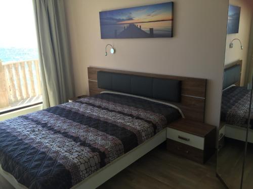 sypialnia z łóżkiem i widokiem na ocean w obiekcie Apartment Kalni Bani w mieście Pomorie