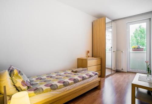 a bedroom with a bed and a dresser and a window at Lovely Corvin Apartment in Budapest