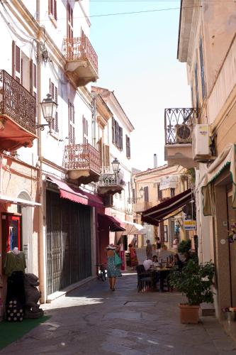 a woman walking down a street with buildings at Blu Baita in La Maddalena