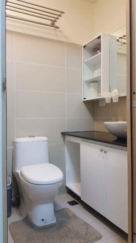 a bathroom with a white toilet and a sink at Tagaytay Condotel in Tagaytay