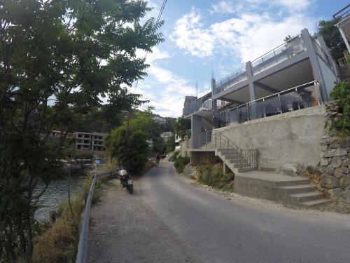 a person riding a motorcycle down a road next to a building at Apartments Klikovac Liman II in Ulcinj