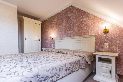 a bedroom with a bed and red wallpaper at Boutique Hotel Annuska in Balatonfüred