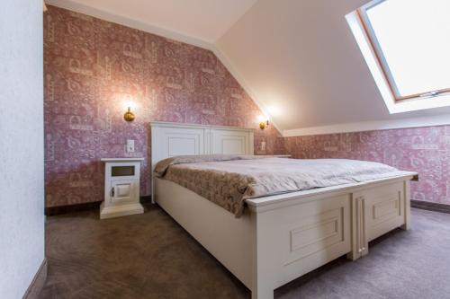 a bedroom with a bed with pink wallpaper at Boutique Hotel Annuska in Balatonfüred