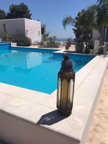 a lantern sitting on the edge of a swimming pool at Villa Mare Di Montelusa in Agrigento