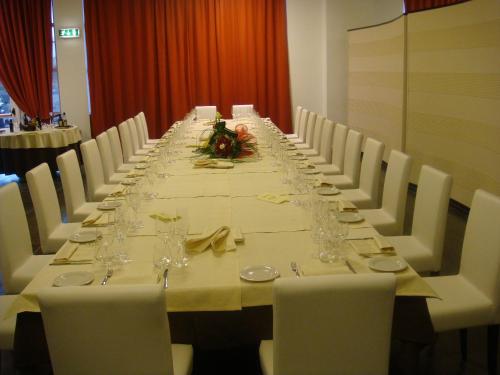 a long table with white chairs and a long table at Santa Loja Hotel Residence in Tito