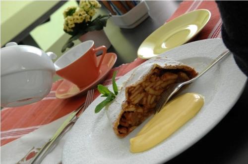 a plate with a piece of food on a table at Hotel Scoiattolo in Tesero