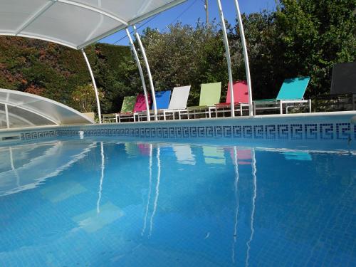 a swimming pool with chairs and a swimming pool at Les Tilleuls B&B in Orange