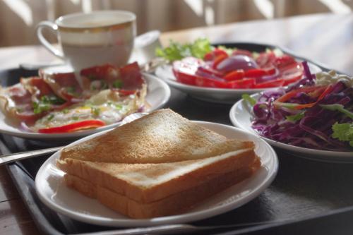 a tray with a sandwich and a salad and a cup of coffee at Lijiang Merry Inn in Lijiang