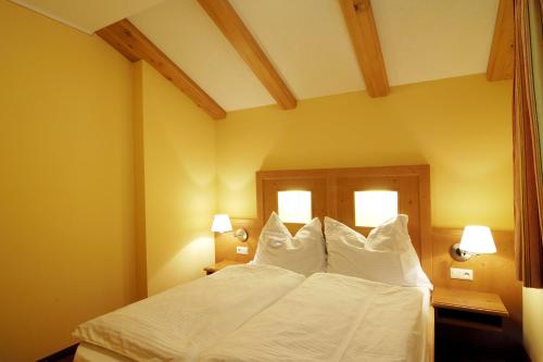 HüttschlagにあるHaus Alpenquellのベッドルーム1室(白いシーツと枕のベッド1台付)