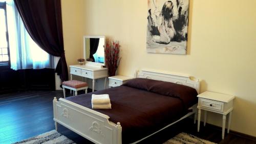 a bedroom with a bed and two tables and a mirror at Casa Remo - Guesthouse in Turda