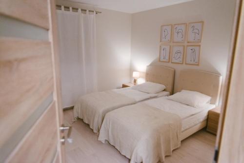 イノヴロツワフにあるSolankowy Apartamentの白い壁の客室で、ベッド2台、鏡が備わります。