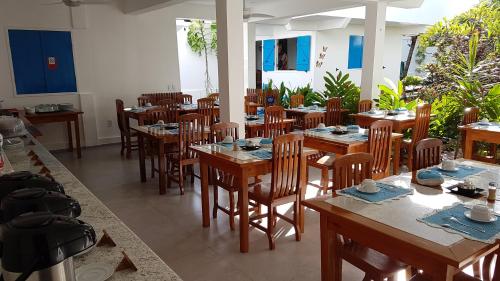 a dining room with wooden tables and chairs at Pousada Caminho da Praia in Jericoacoara