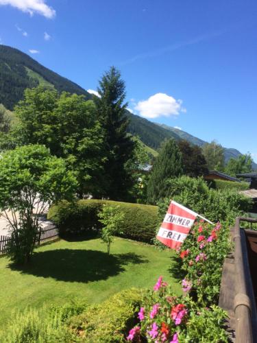 a flag in a yard with flowers and a fence at Landhof Aigner in Mittersill