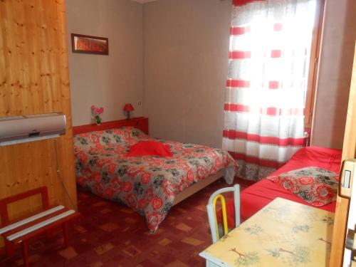 リュス・ラ・クロワ・オートにあるLes 3 Marmottesのベッド2台と窓が備わる小さな客室です。