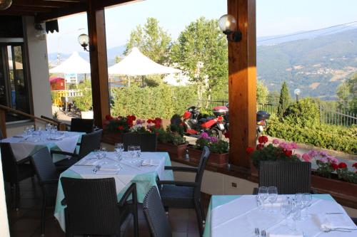 a restaurant with white tables and chairs with a view at Albergo Ristorante Miramonti Toano in Toano
