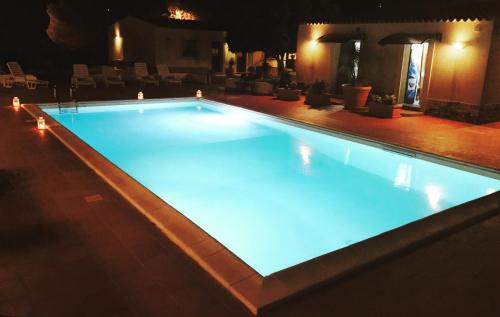 a large swimming pool lit up at night at Locanda Rurale Santa Marta in Avola