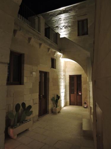 an empty hallway in a stone building with a door at Corte Kalìnora in Martano