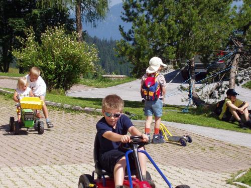 a young boy riding a toy bike with other children at Berghaus Koglmoos in Auffach