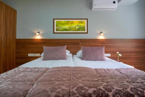 a bedroom with a large bed with two pillows at Green Elite Residence in Sarajevo