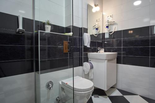 a bathroom with a toilet and a glass shower at Green Elite Residence in Sarajevo