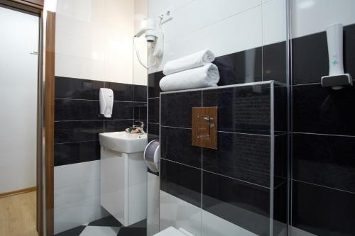 a black and white bathroom with a sink and a toilet at Green Elite Residence in Sarajevo