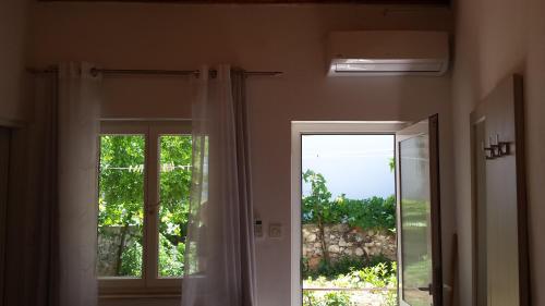 a room with a sliding glass door with a window at Apartment Dinko in Cres