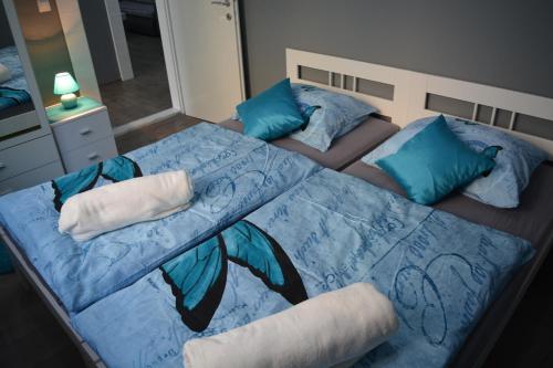 um quarto com uma cama com lençóis azuis e almofadas azuis em Apartment D & N em Kaštela
