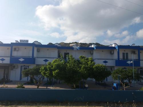 a blue and white building with trees in front of it at Maritsa in Kefalos