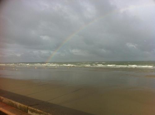 a rainbow over the ocean on a cloudy day at Villa Trémail - La plage au pied de votre chambre in Wimereux