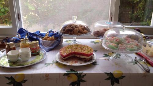 a table topped with plates of food and a cake at La Casa del Limoneto in Favignana