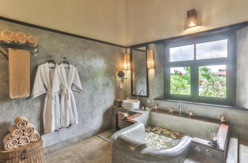 a bathroom with a tub and a sink and a window at Villa Mayurana by Edwards Collection in Koggala