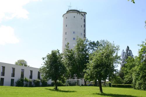 a white building with trees in front of a building at Jugendherberge Otto-Moericke-Turm in Konstanz