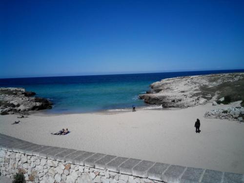 a beach with people on the sand and the ocean at Appartamento Antonacci in Monopoli