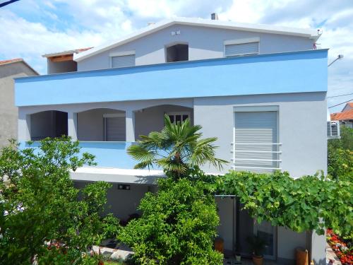 una casa blanca con fachada azul en Apartments & Rooms Marinka, en Zadar