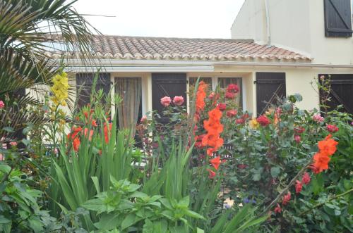 a garden with flowers in front of a house at Chambres d'Hôtes La Forterie in Vairé