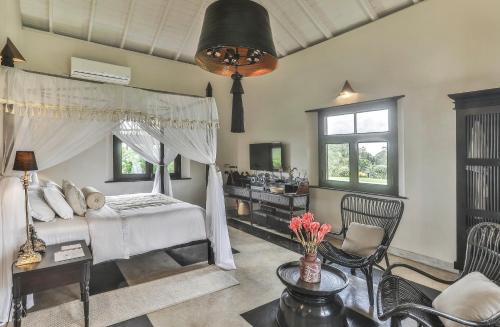 a bedroom with a bed and a table and chairs at Villa Mayurana by Edwards Collection in Koggala